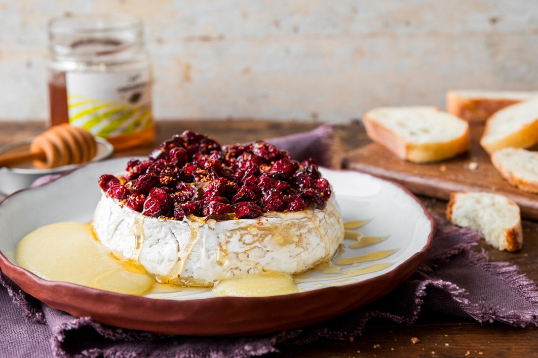 Brie fondant aux canneberges et miel de caméline sur assiette de présentation