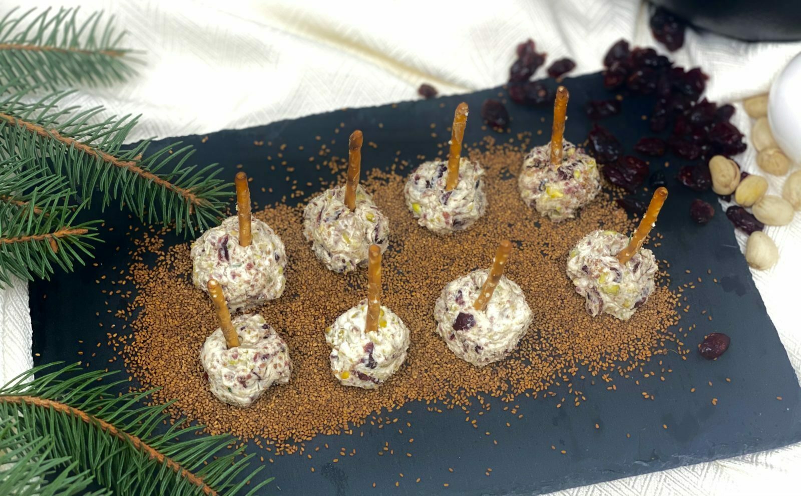 Boules de fromage de chèvre et à la crème avec pistaches, canneberges et de graines de caméline torréfiées sur bâton de pretzel