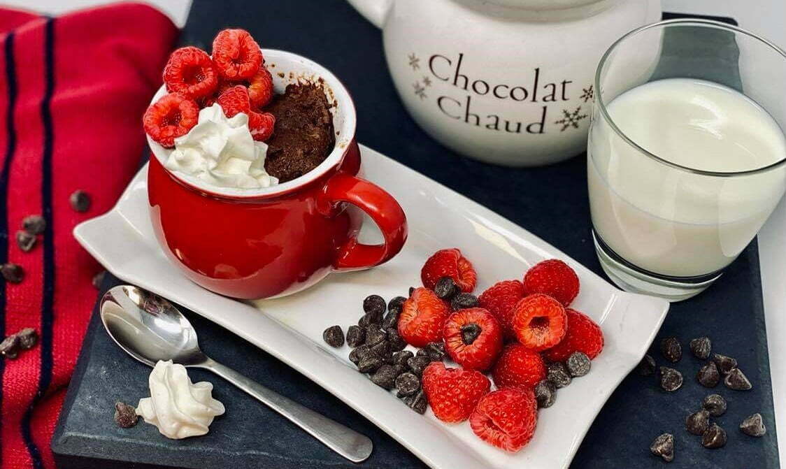 gâteau moelleux dans une tasse avec chocolat et framboises
